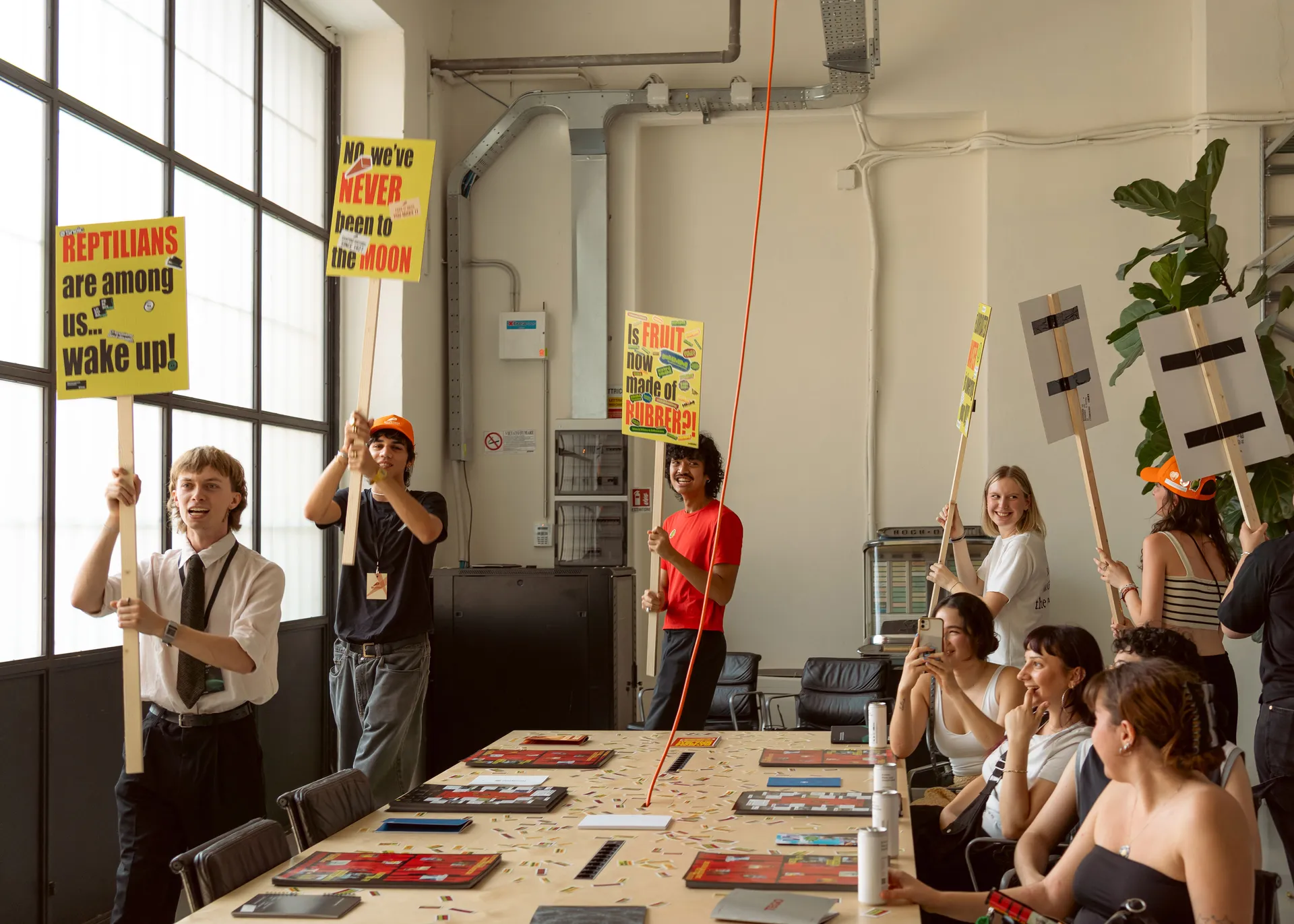 Group of people going around a room with conspiracy theories signs