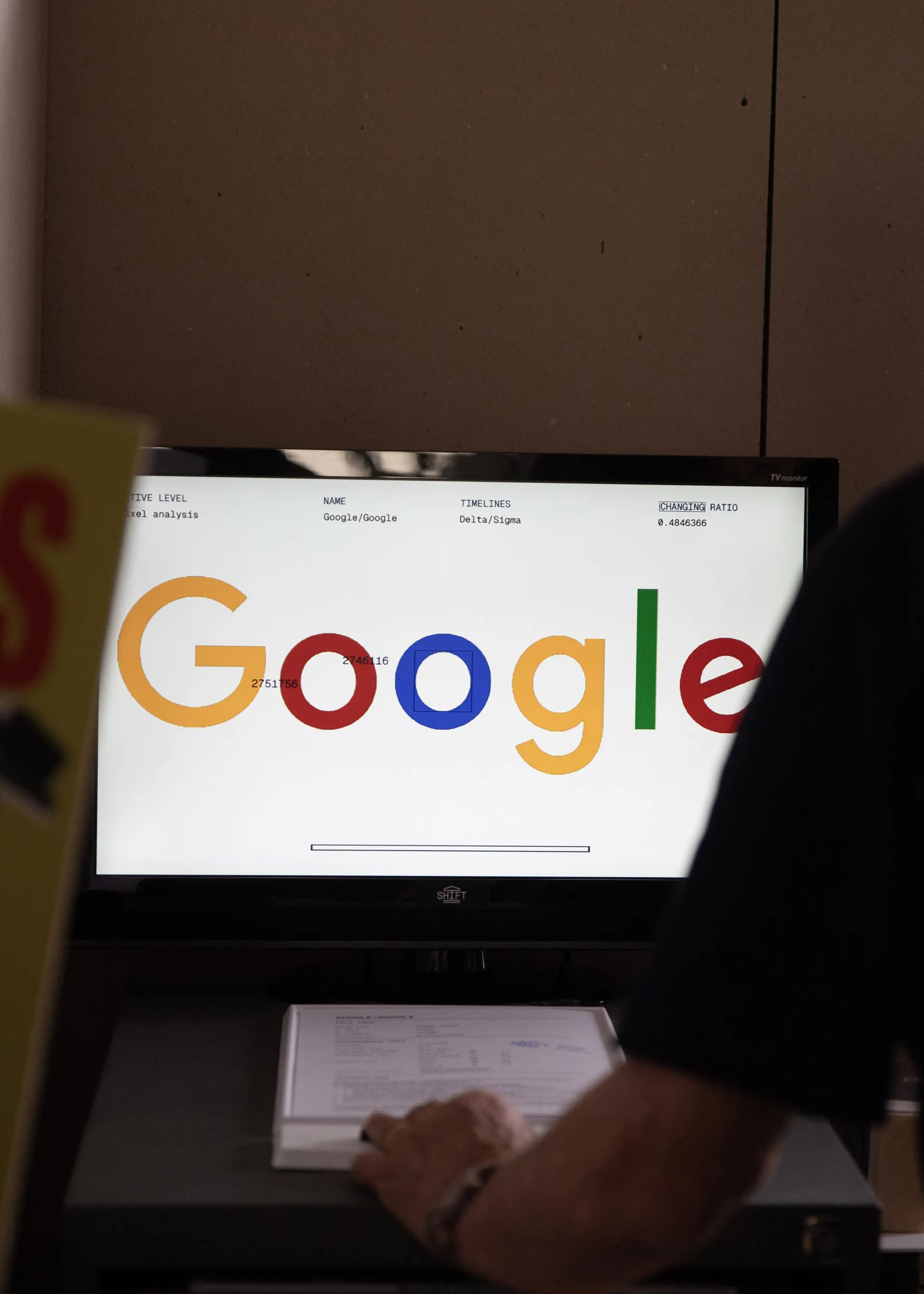 Old man verifying the Google logo with a machine designed for the exhibition by SHIFT